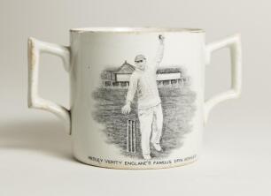 Hedley Verity. Yorkshire & England, 1930-39. A very scarce W. Ellis of Bramley commemorative two handled &lsquo;loving cup&rsquo; mug for &lsquo;Hedley Verity, England&rsquo;s Famous Spin Bowler&rsquo; with vignette of Verity in bowling pose. &lsquo;Record bowling by Hedley Verity&rsquo; to verso