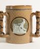 Doulton Lambeth stoneware tyg. Large and impressive three handled tyg with three moulded relief vignettes of cricketers, a batsman, a fielder and wicket keeper in white on a brown background, the sides highly decorated with impressed floral motifs, the ha - 2