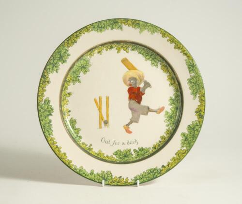 &lsquo;Out for a Duck&rsquo;. A Royal Doulton Black Boy dinner plate, entitled &lsquo;Out for a Duck&rsquo; printed with a boy in red shirt and a floppy hat swinging the bat and being bowled out, the wicket broken. Green floral decoration to outer rim. 10.5&rdquo; diameter. Doulton ba