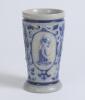 Westerwald stoneware cricket beaker, moulded in relief with three cameo panels of a batsman, after W.G. Grace, in different poses. The body highly decorated with vine and sprig decoration in cobalt blue on a grey background, with the figures highlighted i