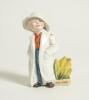 &lsquo;The Boss&rsquo;. Kinsella porcelain caricature spill vase of a young boy dressed as an Umpire in white coat wearing a white floppy hat. Printed title below spill vase. &lsquo;Copyright 482317&rsquo; to base. German, circa early 1900&rsquo;s. Approximately 5.5&rdquo; tall. Damage with