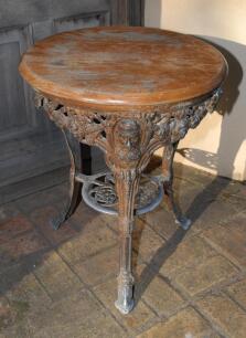 W.G. Grace. Original cast iron circular public house table with circular wooden top, supported by three legs, moulded with portrait busts of Grace wearing cricket cap to top of each leg with imprinted initials &lsquo;W.G&rsquo; above, and decorative pierced apron cen