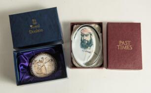 W.G. Grace. Two glass paperweights depicting Grace, one, oval and produced by &lsquo;Past Times&rsquo; wearing M.C.C. cap, 4&rdquo; long and the other by Royal Doulton, circular in form showing Grace at the wicket. 2.75&rdquo; diameter. Both in original boxes. Good condition