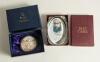 W.G. Grace. Two glass paperweights depicting Grace, one, oval and produced by &lsquo;Past Times&rsquo; wearing M.C.C. cap, 4&rdquo; long and the other by Royal Doulton, circular in form showing Grace at the wicket. 2.75&rdquo; diameter. Both in original boxes. Good condition