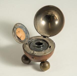Cricket ball inkwell. Leather cricket ball ink well, well made with seam and stitched quarters. The ball, mounted on three ball feet, is split and hinged and opens to reveal a silver metal liner with an original glass ink well. Approximately 2.75&rdquo; circumf