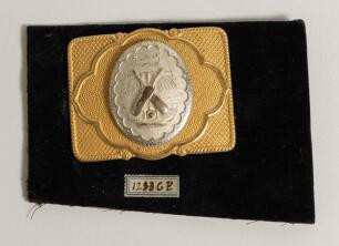 Cricket belt buckle. An excellent oblong shaped belt buckle in soft gilt metal overlaid with silver metal feature to centre, the circular centre decorated with crossed bats stumps and ball over a cricket tent, the outer borders with attractive decorative 