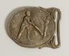Cricket belt buckle. A large oval shaped belt buckle in brass featuring a cricket match in progress with batsman at the wicket striking the ball, a fielder is about to catch him out, a house and trees to background. Circa 1870. Approximately 3.25&rdquo;x2.5&rdquo;. T