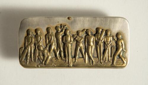 Cricket belt buckle. A larger oblong shaped belt buckle in silver metal over mounted with a brass plate featuring a cricket team of eleven players with bats, balls and wickets, one fielder is throwing the ball in the air. Circa 1870. Approximately 3.5&rdquo;x1.