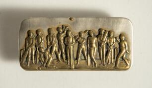 Cricket belt buckle. A larger oblong shaped belt buckle in silver metal over mounted with a brass plate featuring a cricket team of eleven players with bats, balls and wickets, one fielder is throwing the ball in the air. Circa 1870. Approximately 3.5&rdquo;x1.