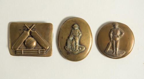 Cricket belt buckles. Three simple brass belt buckles decorated with crossed bats, ball and stumps to one, a batsman posed at the wicket with bat and ball and a further batsman leaning on his bat. One oblong 2.25&rdquo;x1.75&rdquo;, one circular, 2&rdquo; diameter and one 