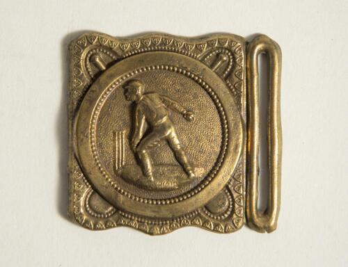 Cricket belt buckle. An almost square shaped brass belt buckle with central figure of a bowler at the wicket to central circle with crossed bat decoration to borders. Circa 1870. Approximately 2.25&rdquo; square. Good condition