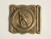 Cricket belt buckle. An almost square shaped brass belt buckle with central figure of a bowler at the wicket to central circle with crossed bat decoration to borders. Circa 1870. Approximately 2.25&rdquo; square. Good condition