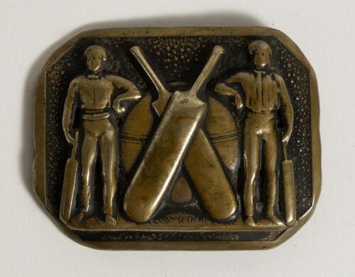 Cricket belt buckle. An oblong shaped brass belt buckle with cricket ball and crossed bats to centre, a cricketer either side appear to be leaning on the ball and holding bats . Circa 1870. Approximately 2.5&rdquo;x2&rdquo;. Good condition