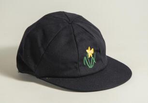 Glamorgan C.C.C. navy blue cloth 1st XI cricket cap with embroidered Glamorgan emblem of the daffodil in bloom to front. Owner unknown. Small moth hole to edge of the peak otherwise in very good condition
