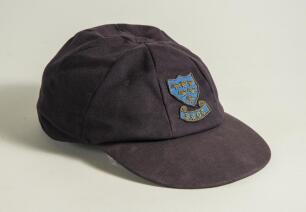 Colin Wells. Sussex 1979-1993. Sussex navy blue 1st XI cloth cricket cap worn by Wells during his playing career. The cap embroidered with the six martlet&rsquo;s emblem of Sussex to front. &lsquo;Bomber&rsquo; handwritten to inner label. Previously sold by Knights to the 