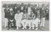 Hampshire C.C.C. 1912. Early original mono postcard of the Hampshire team that beat the touring Australians at Southampton, 22nd- 24th July 1912, the players seated and standing in rows wearing cricket attire, blazers and caps, spectators in the backgroun