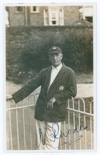 Wilfred Rhodes. Yorkshire & England 1898-1930. Mono real photograph postcard of Rhodes standing three quarter length wearing Yorkshire blazer and cap leaning on the railings, assumed to be at Scarborough. Nicely signed in ink to the photograph Walker&rsquo;s St
