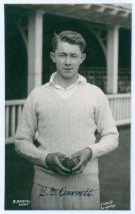 Bruce Stanley Darvell. Kent 1952, 1 match. Mono real photograph postcard of Darvell three quarter length wearing cricket attire and holding a ball. Nicely signed in ink to the photograph by Darvell. Printed title &lsquo;B. Darval [sic], Kent&rsquo; to lower left corn