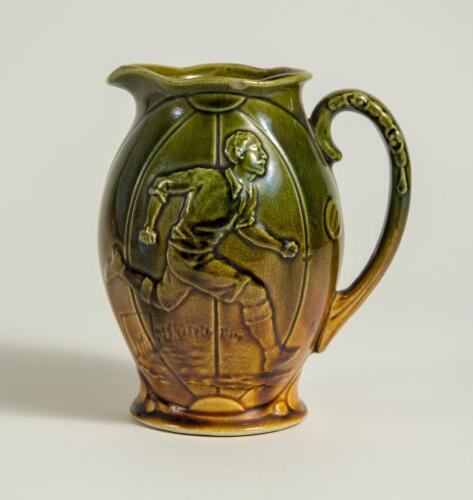 Football/Golf jug. Victorian ceramic jug with image of a footballer running with the ball to one side and a golfer and caddy to the other. Floral and bird decoration. The jug glazed in mustard and green. &lsquo;England&rsquo; to base. 6&rdquo; tall. Small chip to rim other