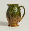 Football/Golf jug. Victorian ceramic jug with image of a footballer running with the ball to one side and a golfer and caddy to the other. Floral and bird decoration. The jug glazed in mustard and green. &lsquo;England&rsquo; to base. 6&rdquo; tall. Small chip to rim other