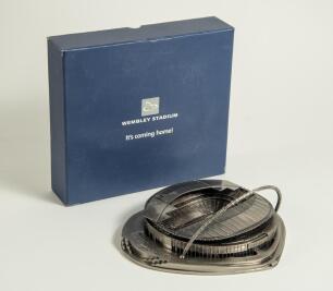 &lsquo;New&rsquo; Wembley Stadium. A pewter model of the new Wembley Stadium in original box, titled to lid &lsquo;Wembley Stadium. It&rsquo;s coming home!&rsquo;. Box measures 9&rdquo;x8.25&rdquo;x2.5&rdquo;. Sold with thirteen modern official programmes for matches played at Wembley 2007-2018 includi