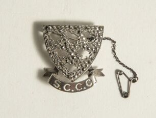 Sussex County Cricket Club pin badge. The silver and marcasite badge with Sussex emblem of the six martlets with &lsquo;S.C.C.C.&rsquo; below. Silver hallmarks for 1975. Complete with safety chain.