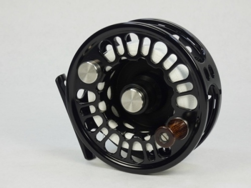 A good Abel Super 7/8N trout/salt-water fly reel, left hand wind model with black anodised finish, counter-balanced rosewood handle, multi-perforated shallow cored drum and backplate, rear spindle mounted tension adjuster, as new condition, in card box an