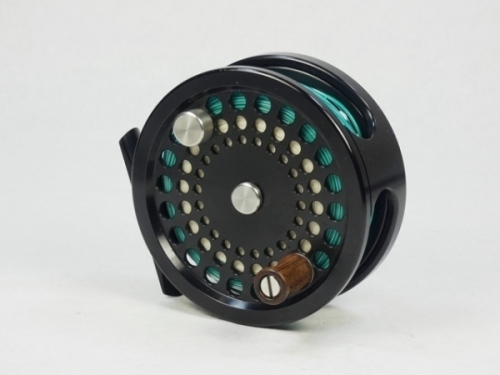 An Aaron 7/8 trout fly reel, left hand wind model with black anodised finish, counter-balanced rosewood handle, rear spindle mounted tension adjuster, light use only, in zip case and a Reddington "TSF" 4 piece carbon trout fly rod, 9', #8, green silk wra