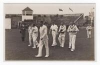 Scarborough Cricket Festival 1927. C.I. Thornton's XI v M.C.C. South African Touring Team, 7th-9th September 1927. Mono real photograph postcard of eight members of the Thornton XI walking on to the field, the grandstand in the background. Players are Mer