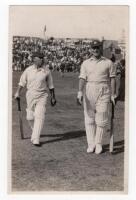 Scarborough Cricket Festival 1933. H.D.G. Leveson-Gower's XI v M.C.C. Australian Touring Team, 6th- 8th September 1933. Mono real photograph postcard of Patsy Hendren and Bill Voce walking off the field in batting attire, large crowds in the grandstand in