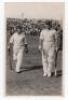 Scarborough Cricket Festival 1933. H.D.G. Leveson-Gower's XI v M.C.C. Australian Touring Team, 6th- 8th September 1933. Mono real photograph postcard of Patsy Hendren and Bill Voce walking off the field in batting attire, large crowds in the grandstand in