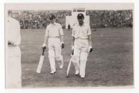 Scarborough Cricket Festival 1936. Yorkshire v M.C.C., 2nd- 4th September 1936. Mono real photograph postcard of Wilcox and Price walking out to bat for M.C.C., the grandstand in the background. Stamp for Walkers Studio, Scarborough, to verso. VG - cricke