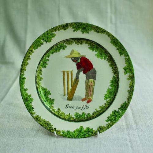 'Good for Fifty'. A Royal Doulton 'Black Boy' bone china dinner plate, entitled 'Good for Fifty' printed with a boy in red shirt and a floppy yellow hat in batting stance in front of the wicket. Green floral decoration to inner and outer rim. 10.25" diame
