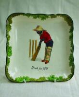 'Good for Fifty'. A Royal Doulton Black Boy square serving dish, printed to centre of the dish with a boy in red shirt, blue trousers and a floppy yellow hat in batting stance in front of the wicket entitled 'Good for Fifty'. Green floral decoration to ou