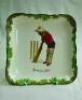 'Good for Fifty'. A Royal Doulton Black Boy square serving dish, printed to centre of the dish with a boy in red shirt, blue trousers and a floppy yellow hat in batting stance in front of the wicket entitled 'Good for Fifty'. Green floral decoration to ou