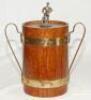 Cricket ice bucket. Wooden two handled metal lined ice bucket. The wooden ice bucket with brass bands similar to a barrel with brass handles. The wooden lid with metal cricketer batsman finial, wearing cap, with bat to side to top. Overall 9.5" tall. Date