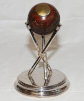 Early cricket ball with silver(?) circular plaque engraved 'C.H.C.C. 2nd XI. Average Ball. 1904. 32 Wickets. Average 5.68. W.C. Entwistle.' The ball standing on a later silver plated stand of three crossed stumps. The stand by Walker & Hall, Sheffield. Ov