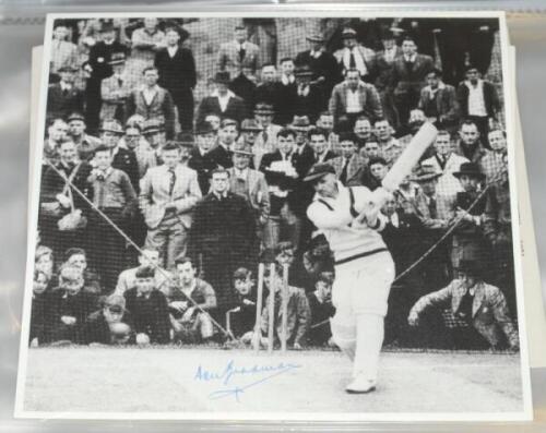 Don Bradman. Black file comprising fifteen mono restrike photographs of Bradman, the majority in batting action on the 1930 tour to England, in the nets, walking on to the field with Norman Yardley, tossing for innings etc. Three photographs signed by Bra