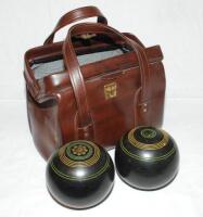 Bowls. A pair of lignum lawn bowling balls in brown fake leather carrying case. Date unknown. VG