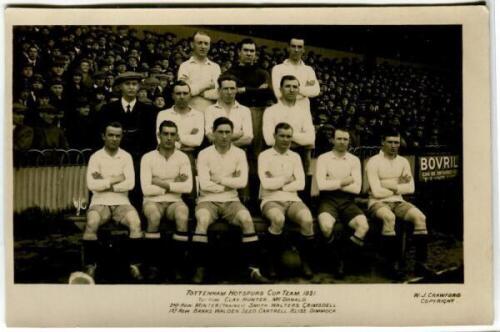 'Tottenham Hotspur Cup Team 1921'. Early mono real photograph postcard of the team and trainer, Minter, standing and seated in rows on the pitch with the large crowd behind them, with printed title 'Tottenham Hotspur Cup Team 1921' and players names print