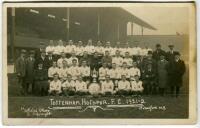 Tottenham Hotspur F.C. 1921/22. Mono real photograph postcard of the playing staff, directors and officials standing and seated in rows with English Cup and Charity Shield to centre, with title printed to lower border 'Tottenham Hotspur. F.C. 1921-22'. W.