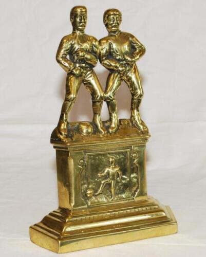 Victorian football brass sporting fire dogs/andiron figures c.1897. Original brass figures in the form of two footballers standing side by side, one with a ball at his feet. The figures stand on a fireplace decorated to centre with a smaller image of a fo