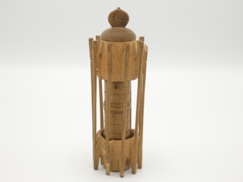 A rare 19th Century treen float and line compendium, the outer wooden receiver carved with ten cast holders (two with minor chips) and with central cylindrical four section cap/shot containers with acorn finial screw top, in original dome topped papier ma