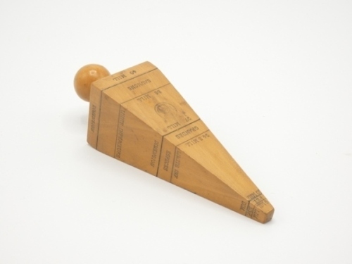 A French yew wood net gauge of tapered square pyramidical form, each side incised and black heightened with detail of legal net size limitation for various species and stamped maker's medallion, knop handle, 5 ½" long (see illustration)
