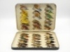 A good Malloch black japanned large rectangular salmon fly box, the cream painted interior fitted bars of nickel silver spring clips and holding a good selection of 36 fully dressed large salmon irons, mainly 7/0 and 6/0 sizes, lid with applied oval nick