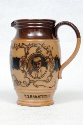 W.G. Grace. Doulton Lambeth stoneware jug with pale body and dark brown rim, decorated with three portraits/roundels of W.G. Grace, K.S. Ranjitsinhji and George Giffen within scrolling foliage. Two tone brown strap handle. Produced in 1896. Approx 7&quot;