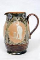Cricketing jug. A large and impressive Doulton Lambeth stoneware jug, of bulbous form, with three moulded relief vignettes of cricketers, a batsman, bowler and wicket keeper, Abel, Woods and McGregor in white on a brown background. With stylised floral le