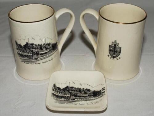 'Pavilion Trent Bridge Cricket Ground'. Two Sandland tankards of similar shape and size, 5&quot;, each with transfer print of the pavilion at Trent Bridge to side, one has the emblem and initials for the 'N.C.C.S.A.' to verso. Sold with a Sandland trinket