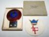 Lord's Taverners car badge. Enamelled metal car badge by Fattorini &amp; Sons, Birmingham, in the form of a cricket ball with red background and initials 'L.T.' below a crown on a central blue enamel roundel. The badge measures approx. 3&quot;x4&quot;. So