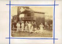 Victorian cricket. Early original albumen sepia photograph c.1870s depicting ten cricketers seated and standing in informal pose wearing cricket attire and assorted blazers and headgear. Behind the players is a two storey wooden chalet style pavilion in a